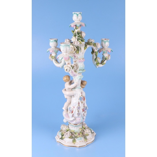 284 - Three continental porcelain figural three-armed candelabra with encrusted flower decoration, 52cms h... 