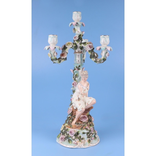 285 - A pair of continental porcelain figural candelabra with flower encrusted decoration (one lacking can... 