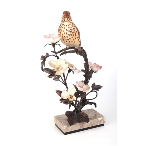 303 - An Albany Fine China model of a song thrush perched in a flowering shrub, 31cms high; together with ... 