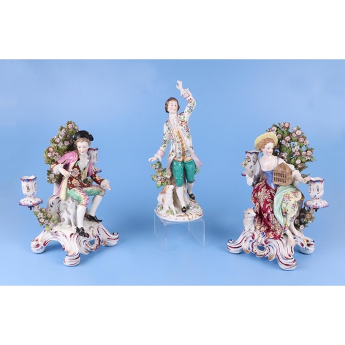 309 - A pair of continental porcelain figural candlesticks depicting a young lady and gentleman seated on ... 