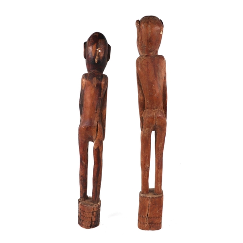 319 - A pair of African carved hardwood male and female fertility figures, each approx 72cms high (2).