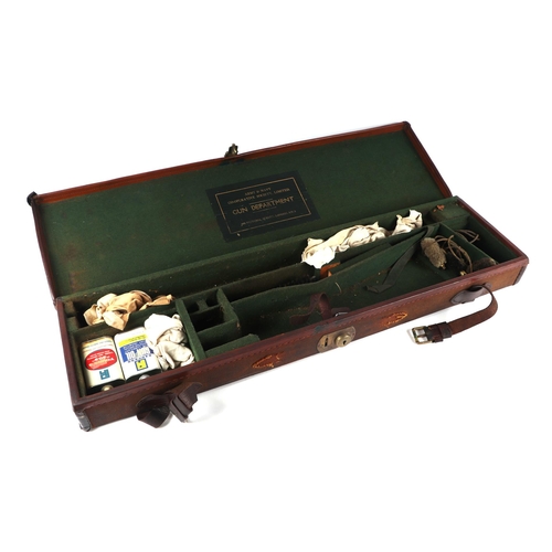 334 - An early 20th century Army & Navy leather trimmed canvas gun case; together with a leather Gladstone... 