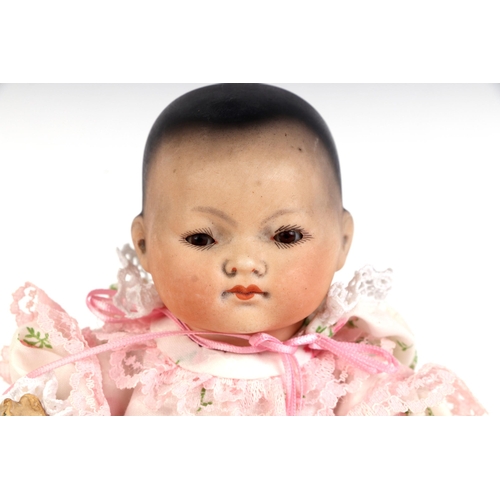 336 - An Armand Marseille bisque headed baby doll with sleeping brown eyes, closed mouth and composite bod... 