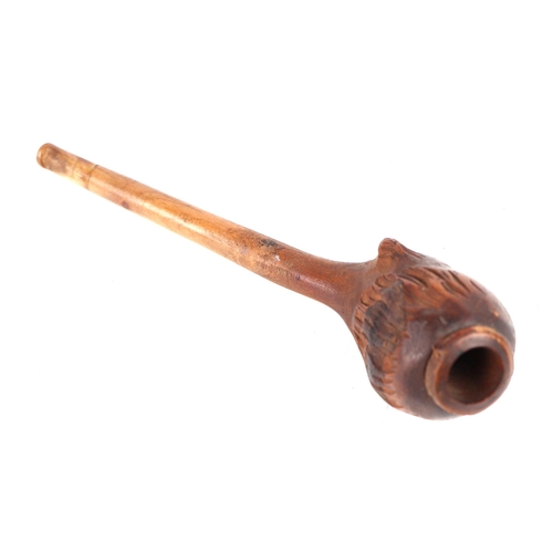 360 - A folk art treen tobacco pipe, the bowl carved in the form of a mans head, 14cms long.