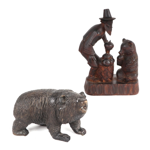 361 - A Black Forest figural group depicting a bear and a man, 15cms wide; together with a  similar carved... 