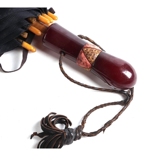 397 - A vintage umbrella with cherry amber Bakelite type handle, 63cms long.