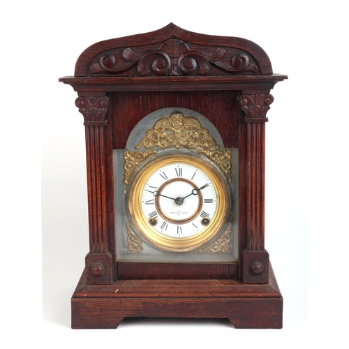 462 - A late 19th century oak cased mantle clock, the white enamel dial with Roman numerals, 27cms wide.