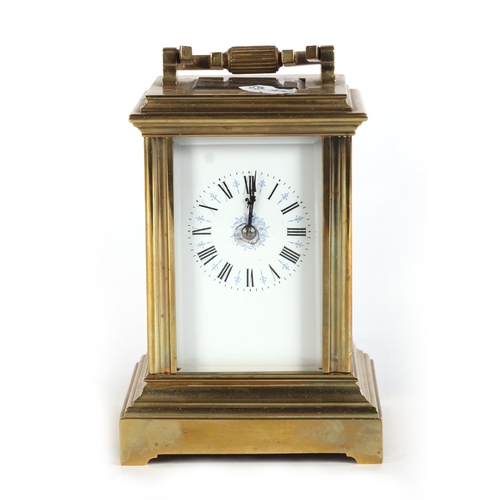 465 - A brass four-pillar carriage clock, the white enamel dial with Roman numerals, 15cms high.