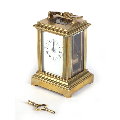 465 - A brass four-pillar carriage clock, the white enamel dial with Roman numerals, 15cms high.