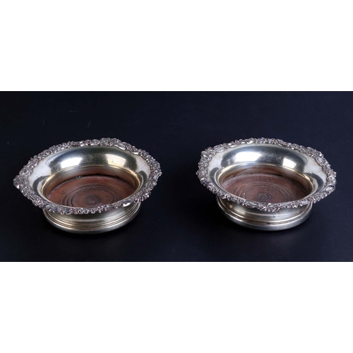 510 - A pair of 19th century silver plated wine coasters; together with a pair of Sheffield plate candlest... 