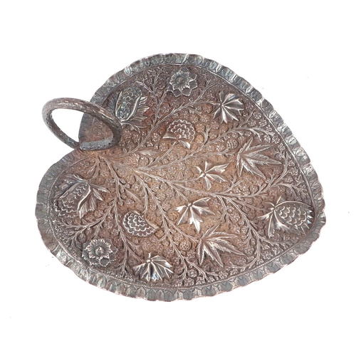 534 - An Indian white metal dish decorated in relief with flowers, 15cms wide, 172g.