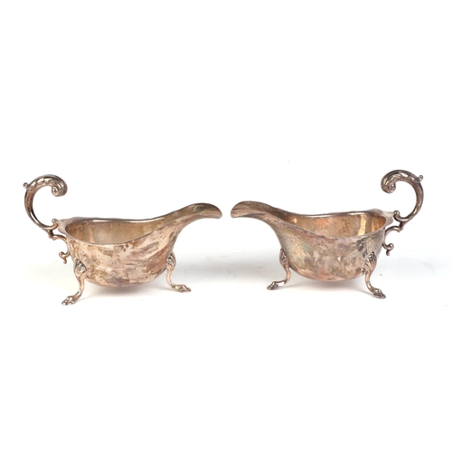 544 - A pair of George V silver sauce boats with scroll handles and shell capped hoof feet, Birmingham 193... 