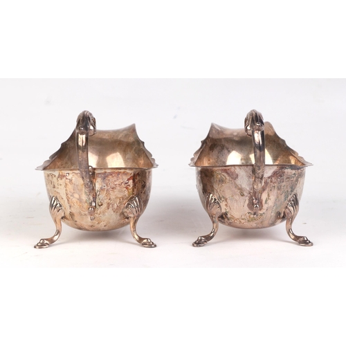 544 - A pair of George V silver sauce boats with scroll handles and shell capped hoof feet, Birmingham 193... 