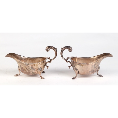 544 - A pair of George V silver sauce boats with scroll handles and shell capped hoof feet, Birmingham 193... 