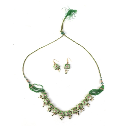 573 - An Indian gilt metal and green foil necklace and matching earrings; another Indian necklace and earr... 