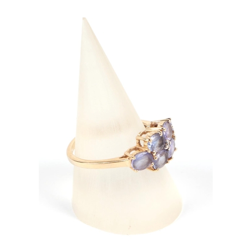 585 - A 14ct gold ring set with six pale purple stones, approx UK size N, 2.8g.