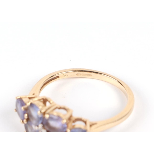 585 - A 14ct gold ring set with six pale purple stones, approx UK size N, 2.8g.