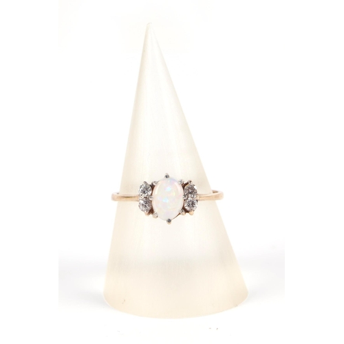 590 - A 9ct gold ring, set with a central opal flanked by four small diamonds, approx UK size L, 1.5g.