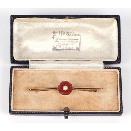 600 - A 15ct bar brooch set with a central flower, pearl and possibly carnelian, 3.6g (boxed).