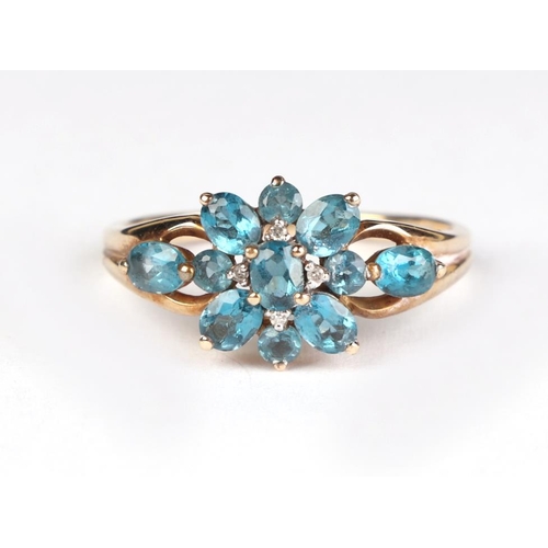 623 - A 9ct gold dress ring set with pale blue stones and diamonds, approx UK size T, 2.9g.