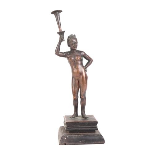 634 - An early 20th century Burmese bronze figure depicting a naked female holding  a torch on an ebonised... 