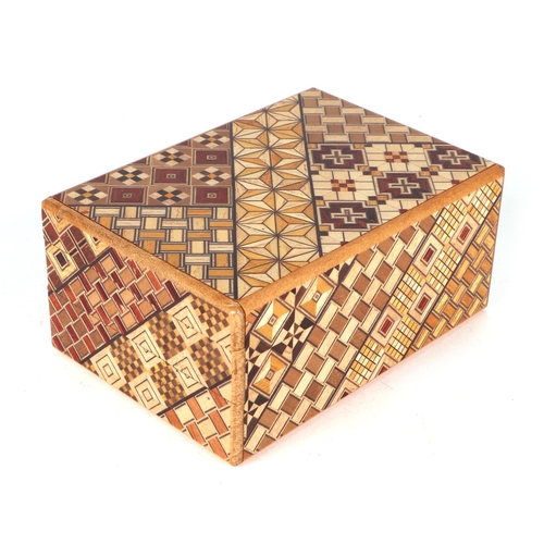 651 - A Japanese Himitsu-Bako wooden puzzle box, 12cms long.