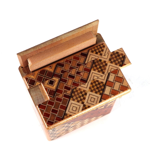 651 - A Japanese Himitsu-Bako wooden puzzle box, 12cms long.