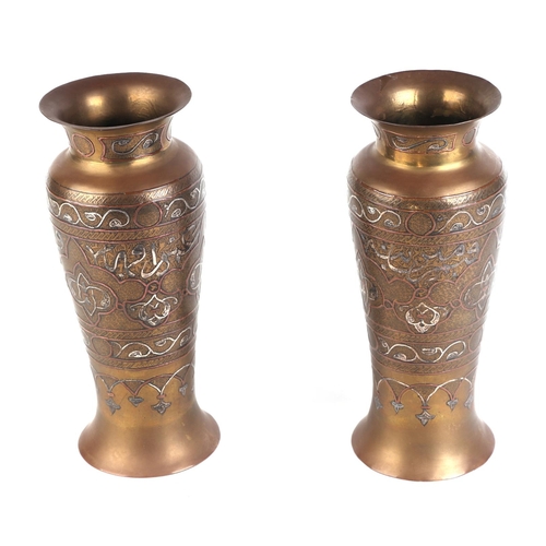 654 - A pair of damascene vases with white metal overlay, 24cms high.