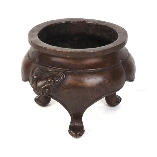 657 - A Chinese bronze tripod censer with lion mask handles, six character mark to the underside, 14cms di... 