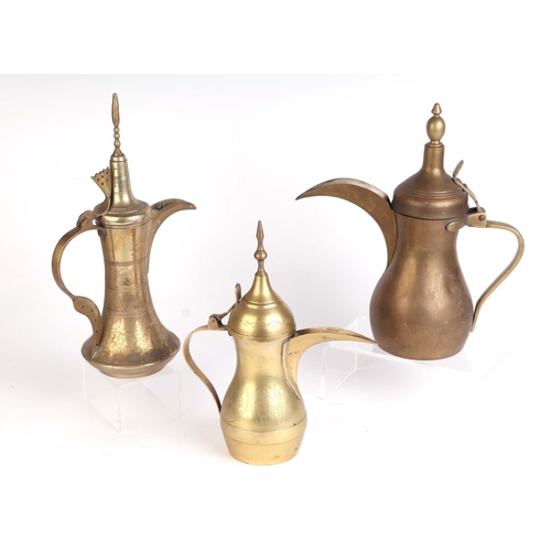 668 - A group of brass Turkish / Islamic dallah coffee pots, the largest 29cms high (3).