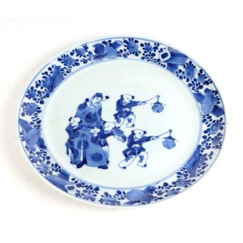 679 - A Chinese blue & white plate decorated with a robed man with four young boys, 22cms diameter.