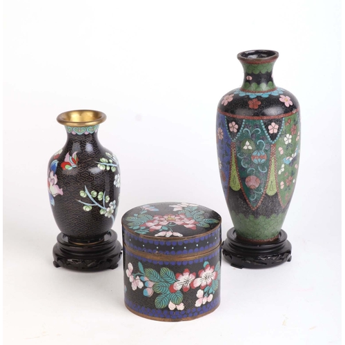 698 - A Chinese cloisonne cylindrical box and cover, 8cms high; together with two cloisonne vases, the lar... 