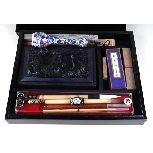 712 - A Chinese calligraphy set to include an ink stone carved with a dragon, a famille rose porcelain bru... 