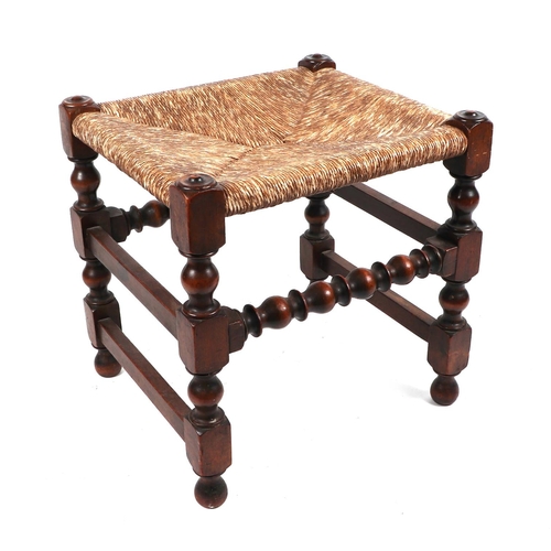 740 - A late 19th century walnut stool with rush seat.