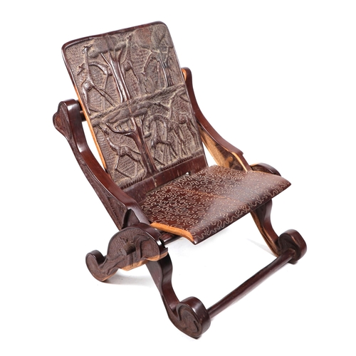 751 - An African hardwood folding chair with a carved panel seat and back.