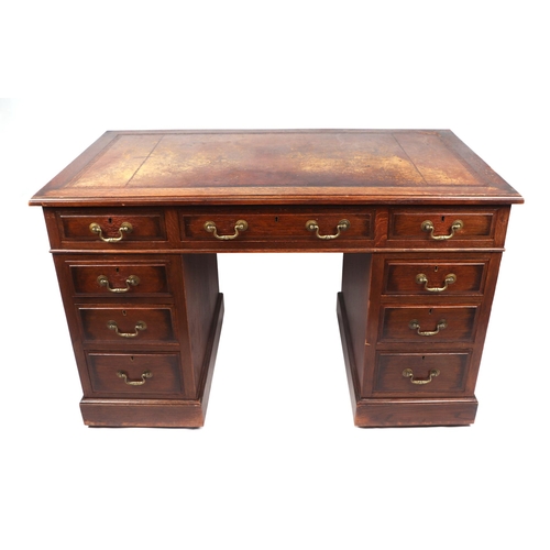 754 - An early 20th century oak pedestal desk with an arrangement of nine drawers, 122cm wide