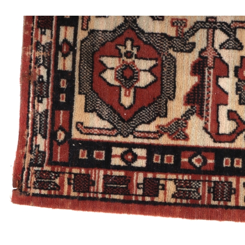 134 - A small Persian rug with central medallion within a multi border, on a dark pink ground, 93 by 134cm... 