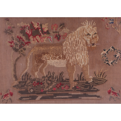 125 - A large framed needlework sampler with a central lion and verse within a meandering flowers by Marta... 