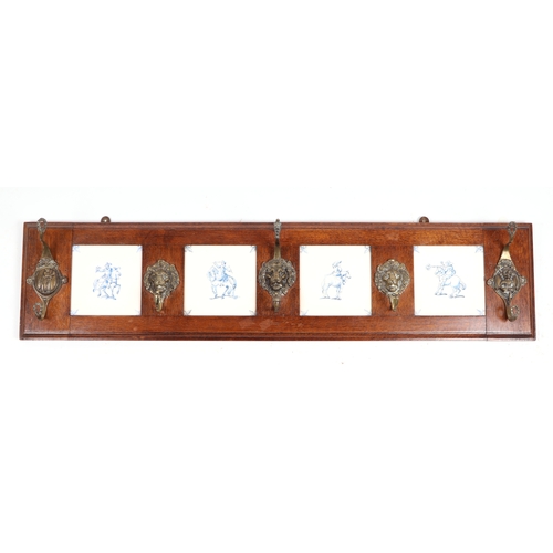 737 - A continental oak coat hooks with four inset Delft blue & white tiles,107cms wide.