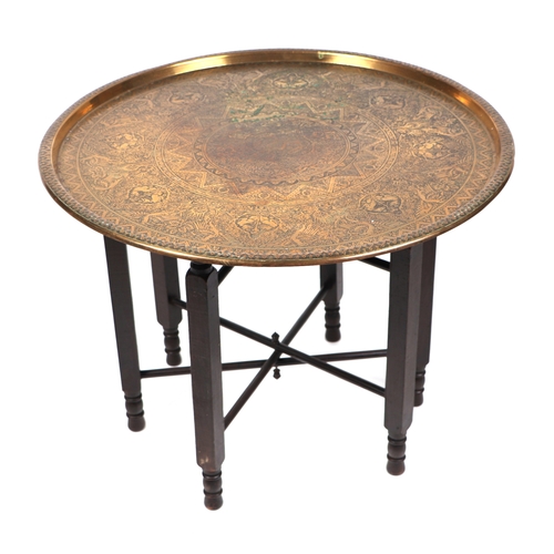 638 - A Middle Eastern brass tray-top table, 59cms diameter.