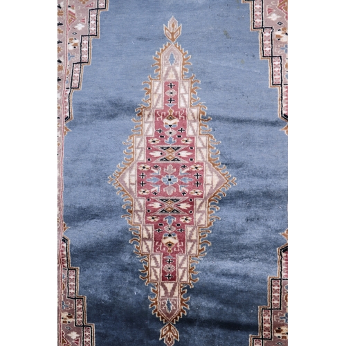 135 - A Persian machine made rug with central medallion within a multi border, on a blue ground, 99 by 155... 