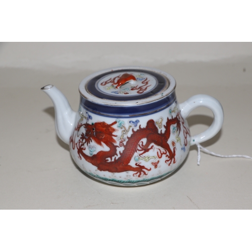 646 - A Chinese porcelain teapot decorated with a pair of five-clawed dragons flying amidst swirling cloud... 