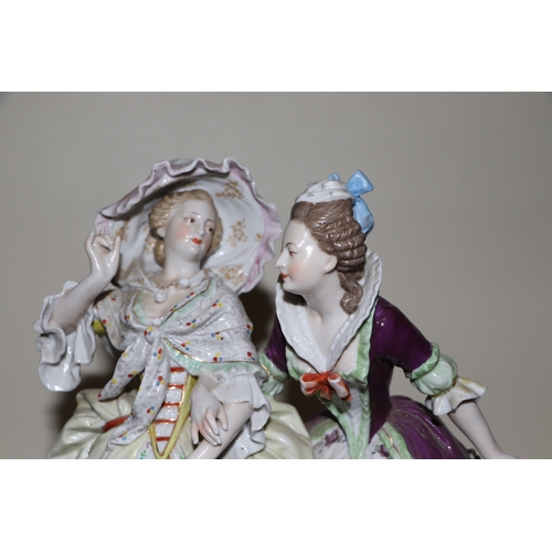 286 - A continental porcelain group depicting two ladies standing by a gate with a spaniel dog, 26cms high... 