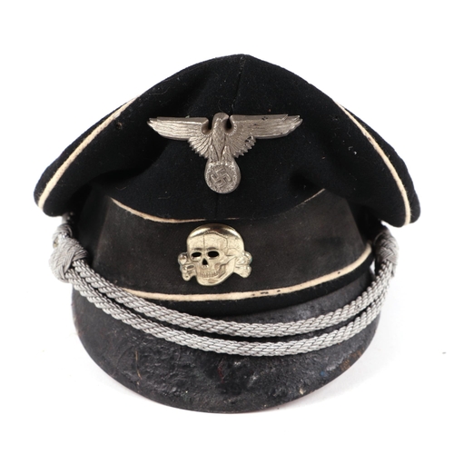 128 - A German peaked cap, together with shoulder epaulettes, aluminium belt buckle, cloth badgers and oth... 