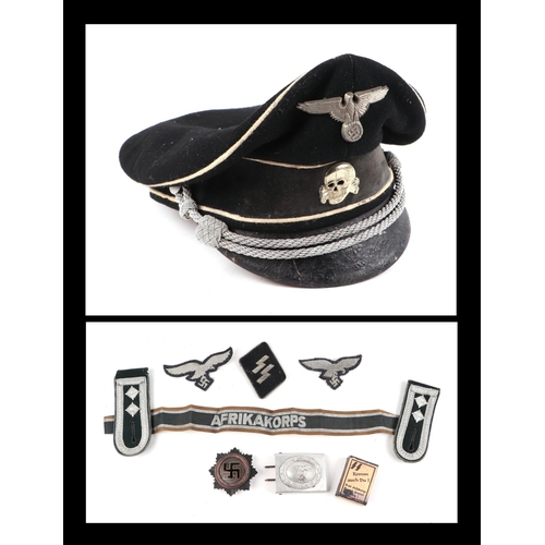 128 - A German peaked cap, together with shoulder epaulettes, aluminium belt buckle, cloth badgers and oth... 