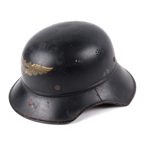 134 - A WWII German Luftschutz steel helmet, with winged decal to the front centre, having leather liner a... 