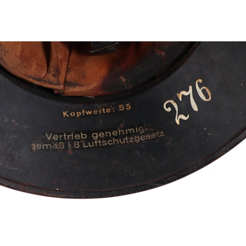 134 - A WWII German Luftschutz steel helmet, with winged decal to the front centre, having leather liner a... 