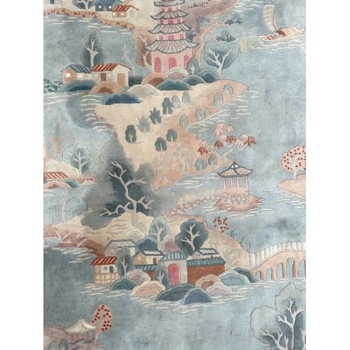 150 - A large Chinese carpet with floral motifs on a blue ground, within a scrolling border, 371 by 272cm.