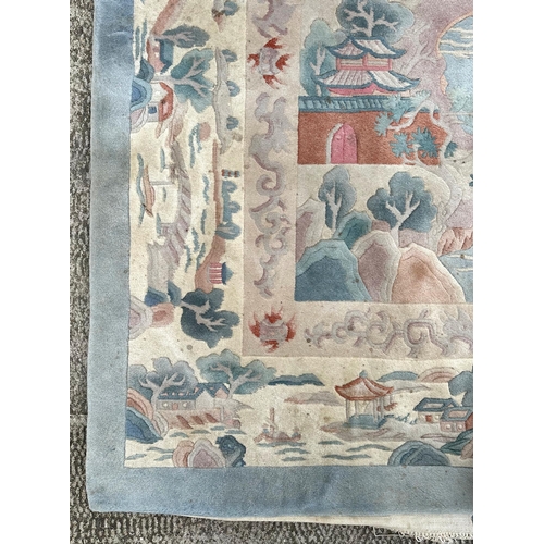 150 - A large Chinese carpet with floral motifs on a blue ground, within a scrolling border, 371 by 272cm.