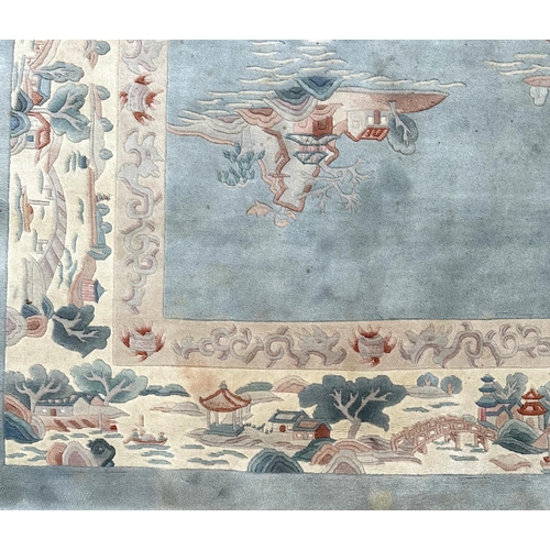 150 - A large Chinese carpet with floral motifs on a blue ground, within a scrolling border, 371 by 272cm.